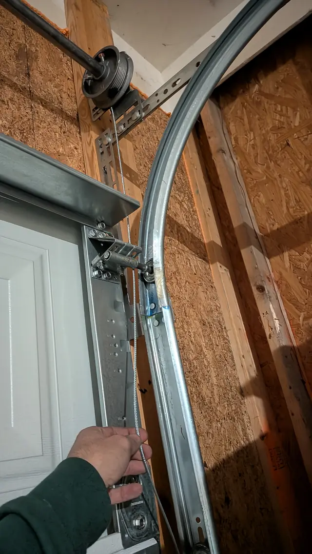 Technician adjusting garage door track hardware