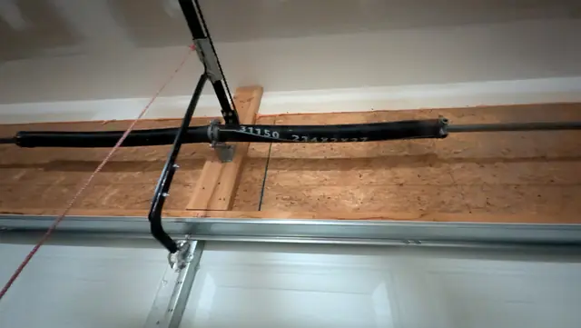 Torsion spring and cable drum mounted above a garage door